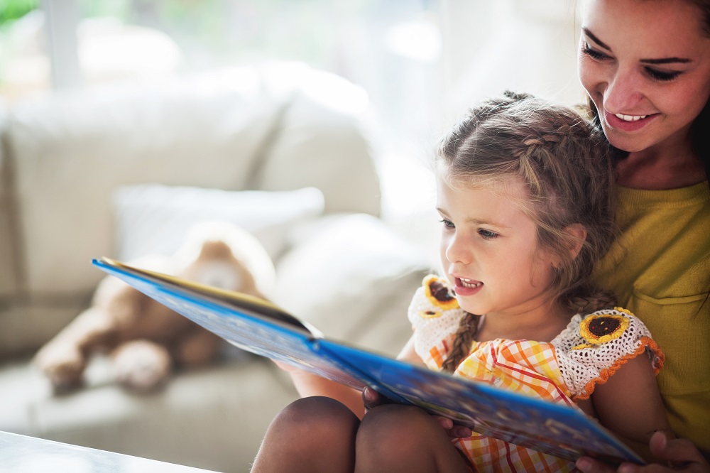 An image of a woman and girl reading a book.