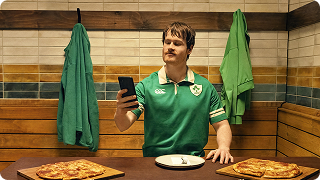 A Rugby player holding a smartphone.